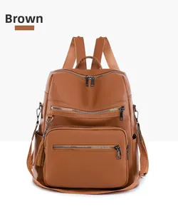 Close-up of brown textured leather backpack featuring front zipper pockets and decorative tassel