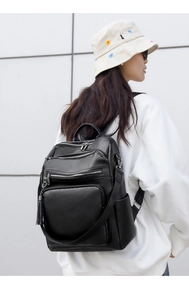 Detail view of black PU leather backpack with multi-zipper pockets and tassel zippers