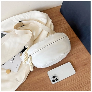 Macro view of cream crescent crossbody bag featuring unique thick rope zipper puller