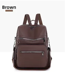 Detail of coffee brown faux leather backpack with tassel charms and multi-zipper pockets
