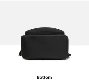 Flat lay detail showing the wide flat bottom and sturdy stitching of the black nylon backpack
