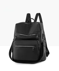 Side view of black pebble leather backpack with decorative tassels and multi-pocket design