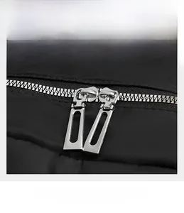 Detail of durable dual metal zippers on water-resistant black nylon travel backpack
