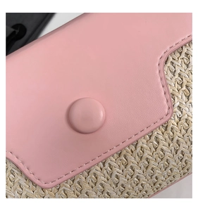 Detail der rosa Lederklappe und der natürlichen Strohgeflecht-Struktur der Umhängetasche