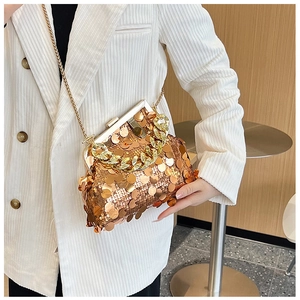 Detail of champagne gold sequin texture and metallic chain strap on a fashion clutch bag