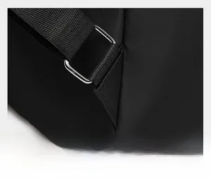 Detail of reinforced triangular stitching and silver metal buckle on nylon backpack strap