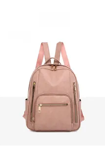 Front view of pink faux leather backpack with gold zippers and pebbled texture detail