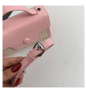 Detailansicht der rosa Ledertasche mit Nähten und silberner Metallschnalle am Riemen