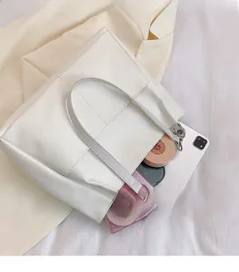 Detail view of white tote bag showing large capacity for tablet and makeup storage