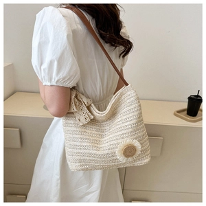 Close-up of beige woven tote bag with white lace bow and delicate daisy ornament