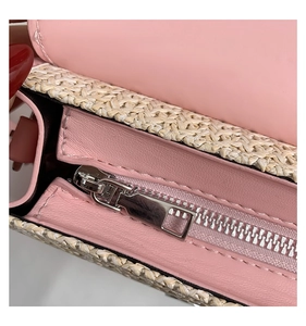 Detail von rosa Leder und Strohgeflecht-Struktur mit silbernem Reißverschluss an der Tasche