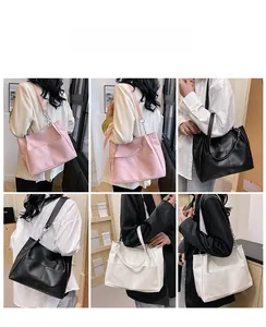 Detail view of large tote bags in pink, black, and white with silver chain accents