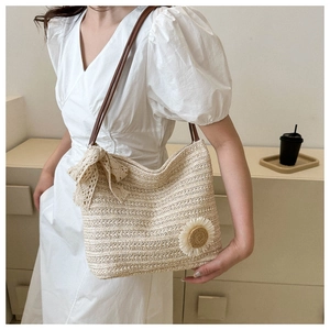 Detail showing the sunflower patch and lace bow on this woven straw tote bag