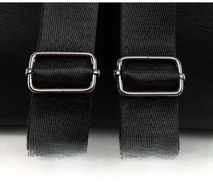 Detail of adjustable nylon straps with silver metal buckles on black faux leather backpack