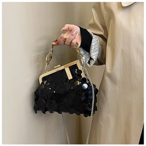 Detail of black sequin evening bag with gold T-bar clasp and chunky chain handle