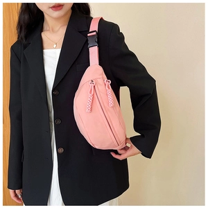 Close-up of pink nylon chest bag with adjustable strap and buckle for casual wear
