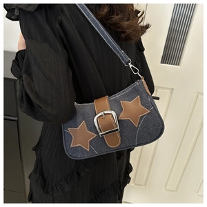 Detail of vintage denim shoulder bag with leather star patches and Y2K metal chain