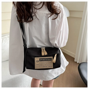 Detail van zwarte Oxford stoffen crossbody tas met verstelbare riem en sportpatch