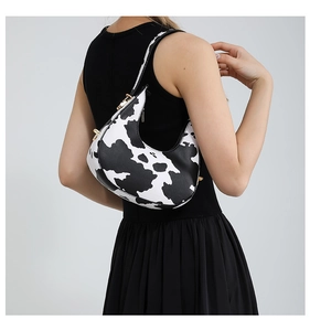 Detail of a crescent zebra pattern underarm bag with gold zipper and saddle shape