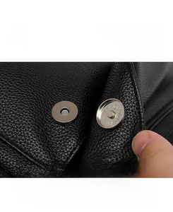 Close-up of black lychee texture leather backpack with silver magnetic buckle detail