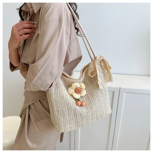 Detail of straw tote bag with sunflower accents, cherry charms, and lace bow decor