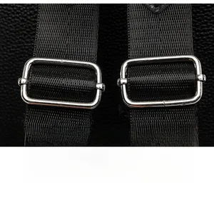 Macro shot of adjustable shoulder strap with silver buckle on black leather backpack