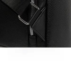 Detail view of the reinforced triangular stitching on litchi leather backpack straps