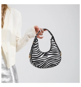 Detailed view of the zebra pattern handbag with gold-tone hardware and half-moon silhouette