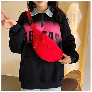 Detail of red nylon waist bag featuring adjustable strap and black buckle closure