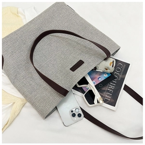 Detailed interior view of a gray linen tote bag filled with lifestyle essentials