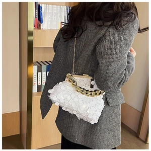 Detail of white sequin crossbody bag with gold chain strap on a grey blazer outfit