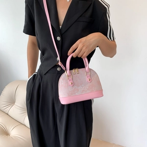 Sac à main coquillage en jacquard rose avec zips dorés et bandoulière cuir