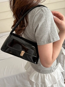 Classic black patent leather underarm bag with gold buckle shown on a model