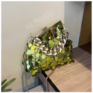 Macro detail of green sequins and gold chain handle on a stylish evening clutch bag