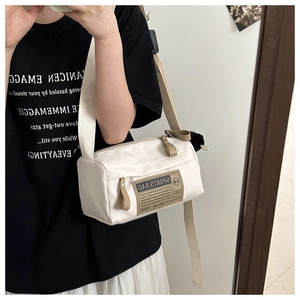 Spiegel-selfie van de gebroken witte Oxford stoffen crossbodytas met pluizige hanger