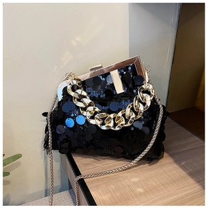Detail of black sequin clutch bag with gold metal frame and thick chain handle