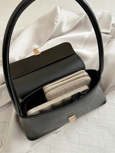 Chic black patent leather baguette shoulder bag with gold clasp and spacious interior