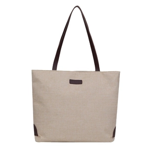 Minimalist beige linen tote bag with brown leather handles and fashion logo tag