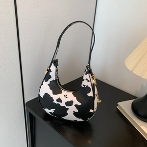 Chic cow print crescent hobo bag for women with golden hardware and leather strap