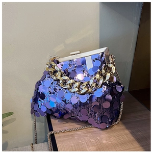 Detailed shot of shimmering purple sequins and luxury gold chain on the evening handbag