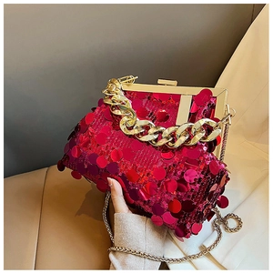 Detailed macro view of vibrant red sequined evening clutch bag with thick gold chain handle