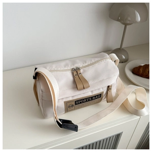 Detailopname van de crèmekleurige canvas sporttas met XM SPORTS-label op tafel