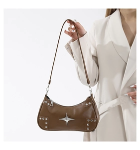 Détail d'un sac hobo en cuir marron avec ornement étoile argentée et rivets