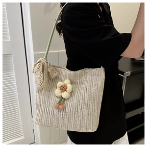 Detail of sunflower straw tote bag with lace bow and woven floral accents