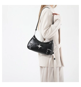 Détail du sac bandoulière en cuir noir avec matériel d'étoile argentée et rivets chic