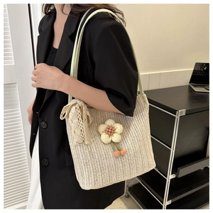 Detail of straw tote bag featuring lace bow and floral pendant with model shot