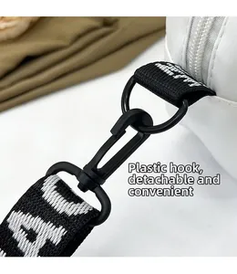Detail of the detachable plastic hook and black-and-white lettered nylon bag strap