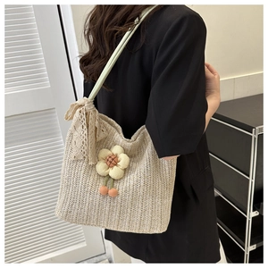 Detail of sunflower straw tote bag with lace bow and plush charms for beach vacation