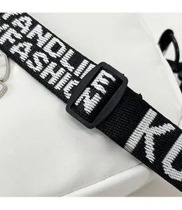 Macro shot of nylon bag featuring adjustable shoulder strap with FASHION lettering detail