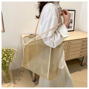 Primer plano del bolso tote de malla beige con textura de rejilla transpirable y asas fijas